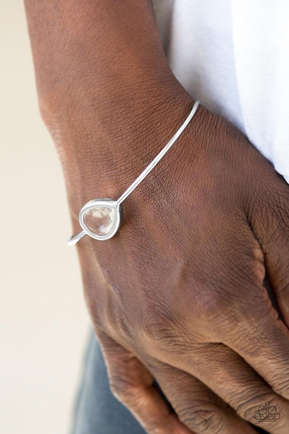 Paparazzi Accessories Make A Spectacle - White A glassy white gem is pressed into a teardrop fitting in the center of a dainty silver cuff for a refined look. Jewelry