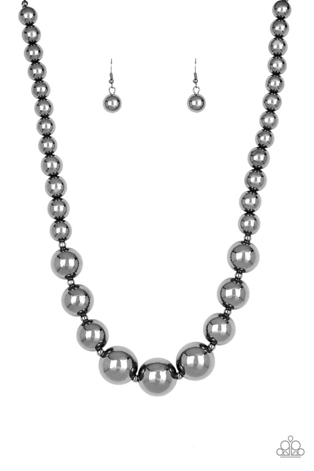 Paparazzi Accessories Living Up To Reputation - Black A collection of bold gunmetal beads are threaded along an invisible wire below the collar. The glistening beads dramatically increase in size as they reach the center for an undeniable statement-making