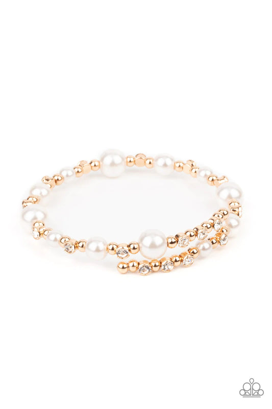 Paparazzi Accessories Chicly Celebrated - Gold A chic collection of white pearls, dainty gold beads, and glassy white rhinestones are threaded along a dainty wire that delicately coils around the wrist for a timeless twist. Sold as one individual bracelet