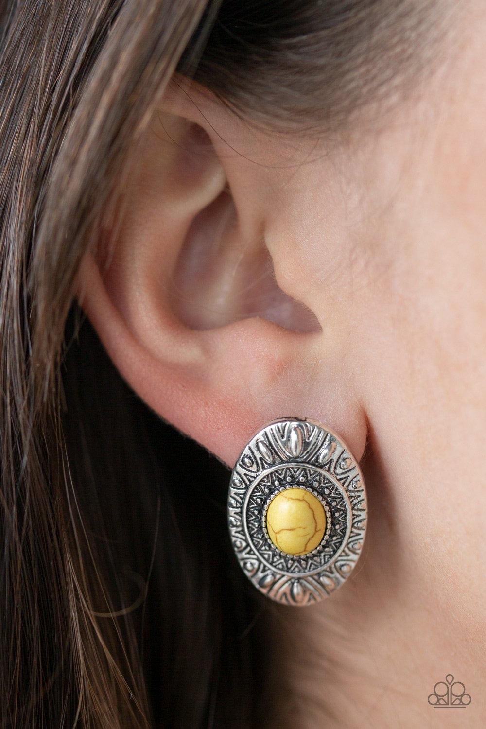 Paparazzi Accessories Stone Tiki - Yellow A sunny yellow stone is pressed into the center of an ornate silver frame radiating with sunburst and studded patterns for a tribal inspired look. Earring attaches to a standard post fitting. Jewelry
