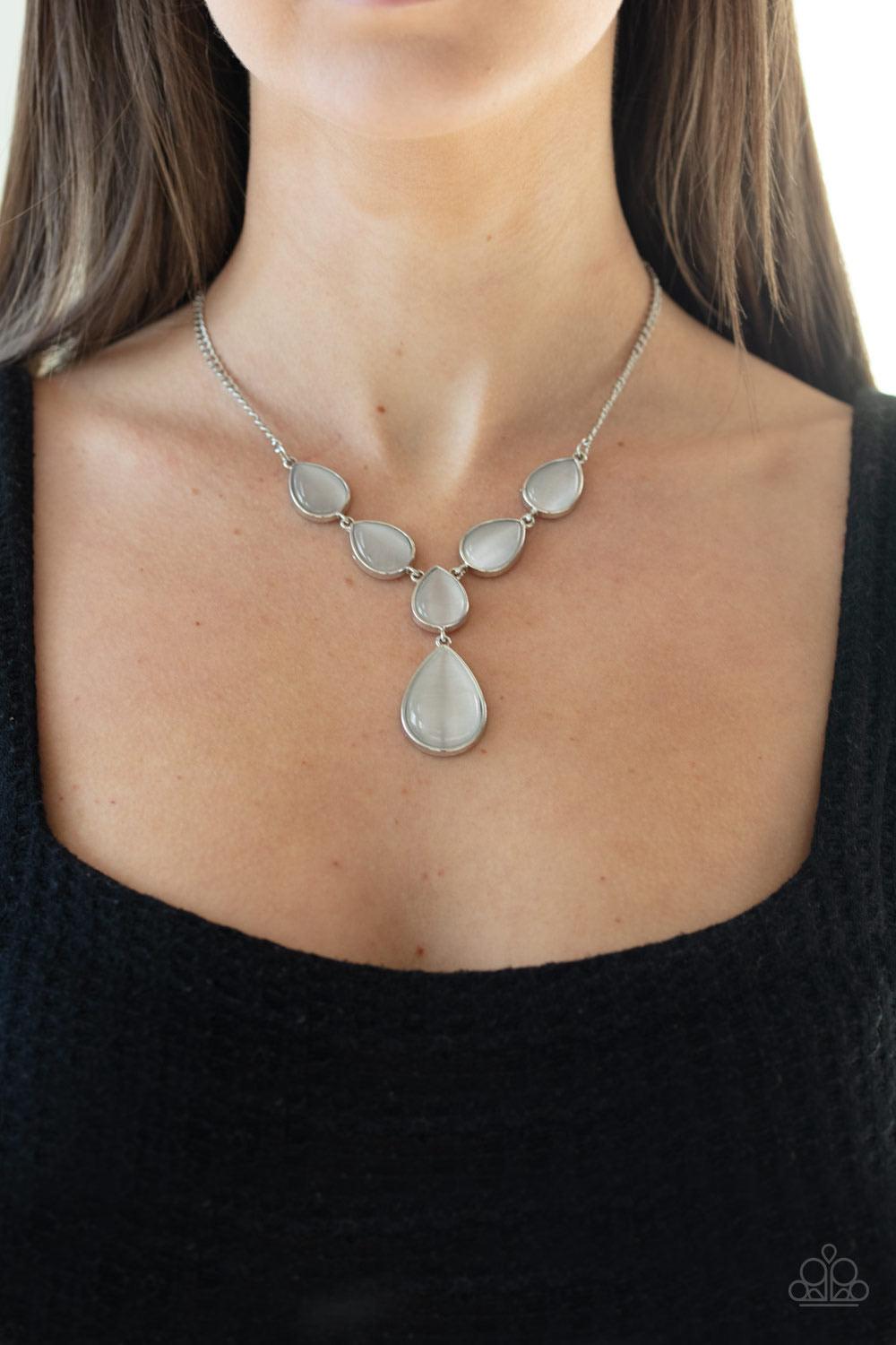 Paparazzi Accessories Dewy Decadence - White A series of white cat's eye teardrops interlock at the bottom of a silver chain, giving way to an oversized teardrop pendant for a refined finish. Features an adjustable clasp closure. Jewelry