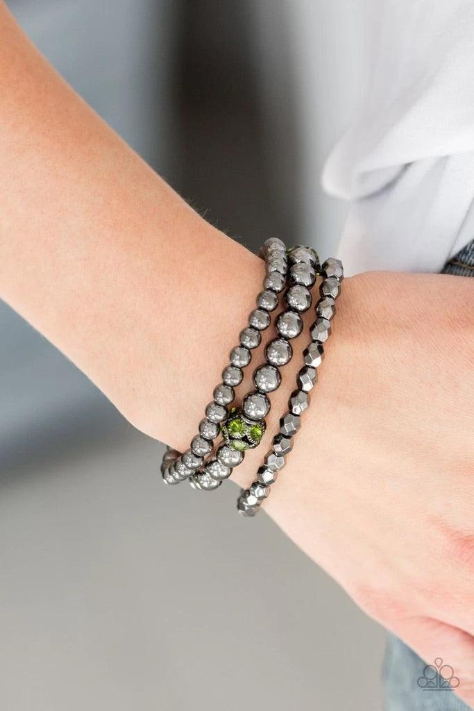 Paparazzi Accessories Noticeably Noir - Green Mismatched gunmetal beads and green rhinestone encrusted beads are threaded along stretchy bands for an edgy and refined look. Sold as one set of three bracelets. Bracelets