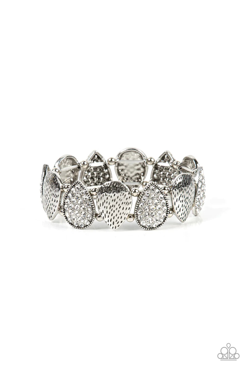 Paparazzi Accessories Playing Favorites - White Infused with pairs of silver beads, a decorative collection of hammered silver teardrops, and white encrusted silver teardrops alternate along stretchy bands around the wrist for an edgy flair. Sold as one i