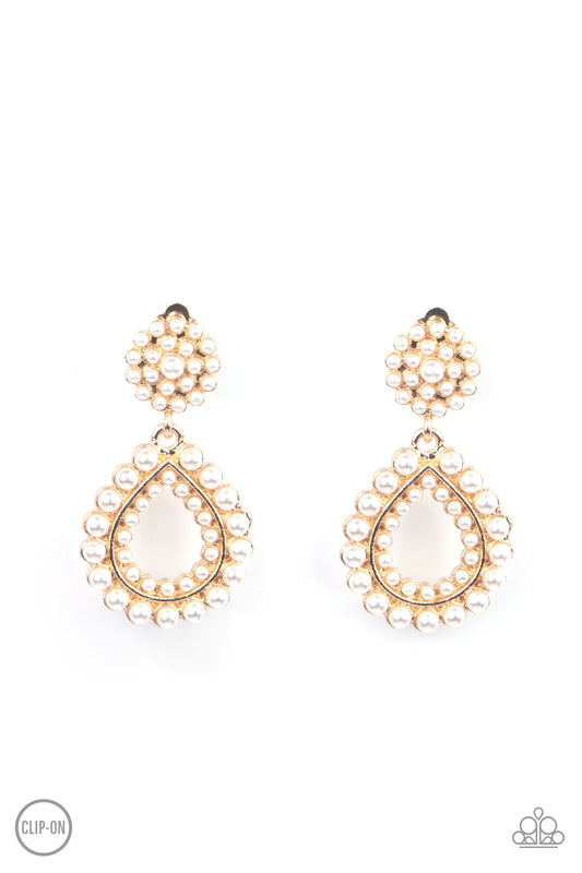 Paparazzi Accessories Discerning Droplets - Gold *Clip-On Droplets of pearls dot the surface of a gold teardrop frame that suspends from a round pearl encrusted disc for a classic finish. Earring attaches to a standard clip-on fitting. Sold as one pair of