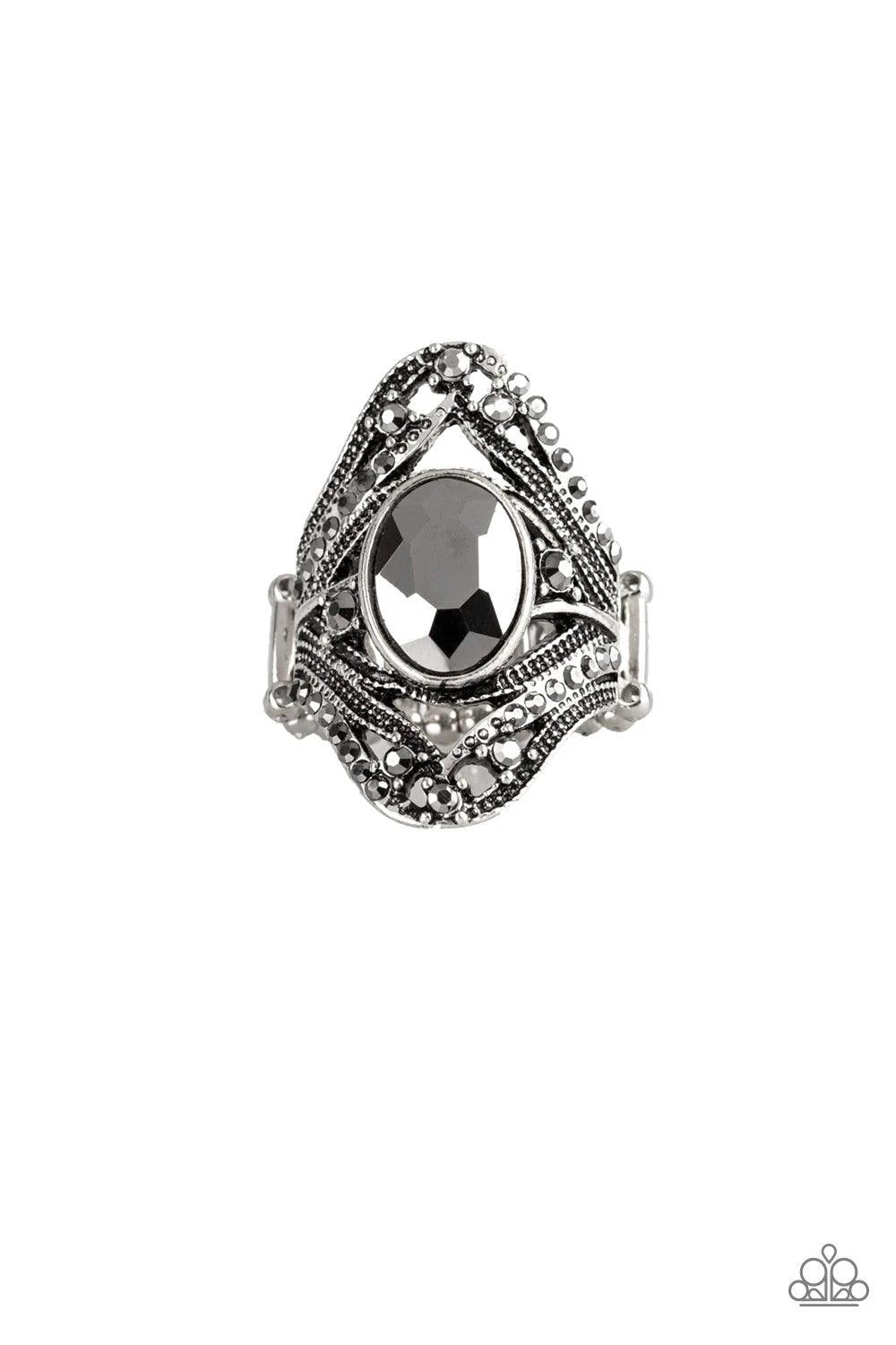 Paparazzi Accessories Red Carpet Rebel - Silver Radiating with dainty hematite rhinestones, studded silver bands whirl across the finger, coalescing into an ornate frame. An over sized hematite rhinestone is pressed into the center of the band for a drama