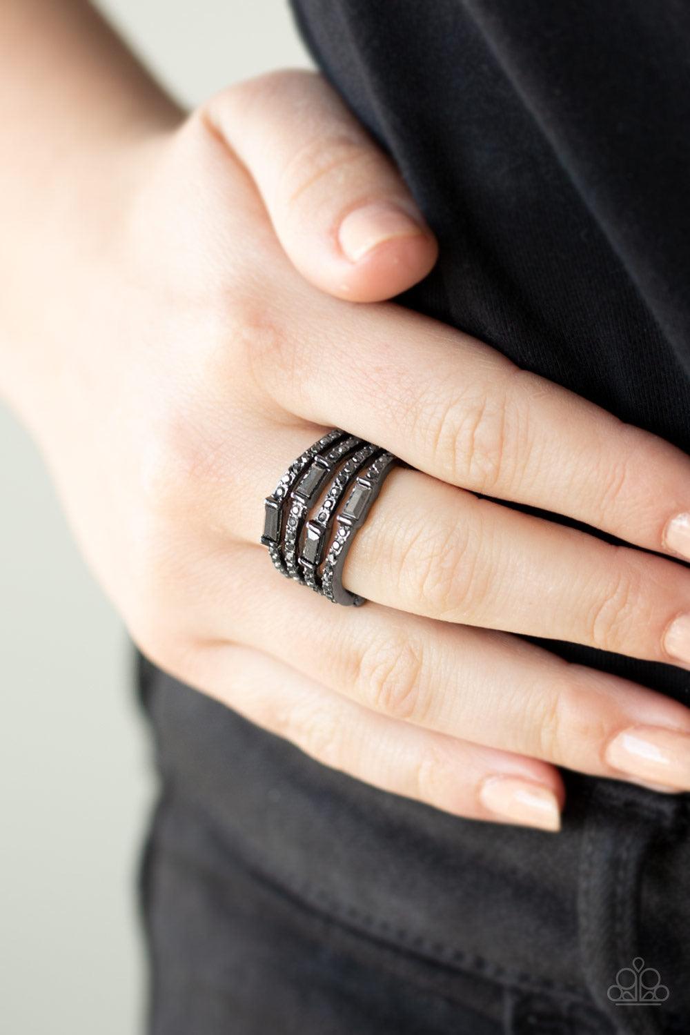 Paparazzi Accessories Royal Reflections - Black Wavy gunmetal bands are encrusted in sections of dainty hematite rhinestones and emerald-cut hematite rhinestones for a sassy layered look. Features a stretchy band for a flexible fit. Jewelry