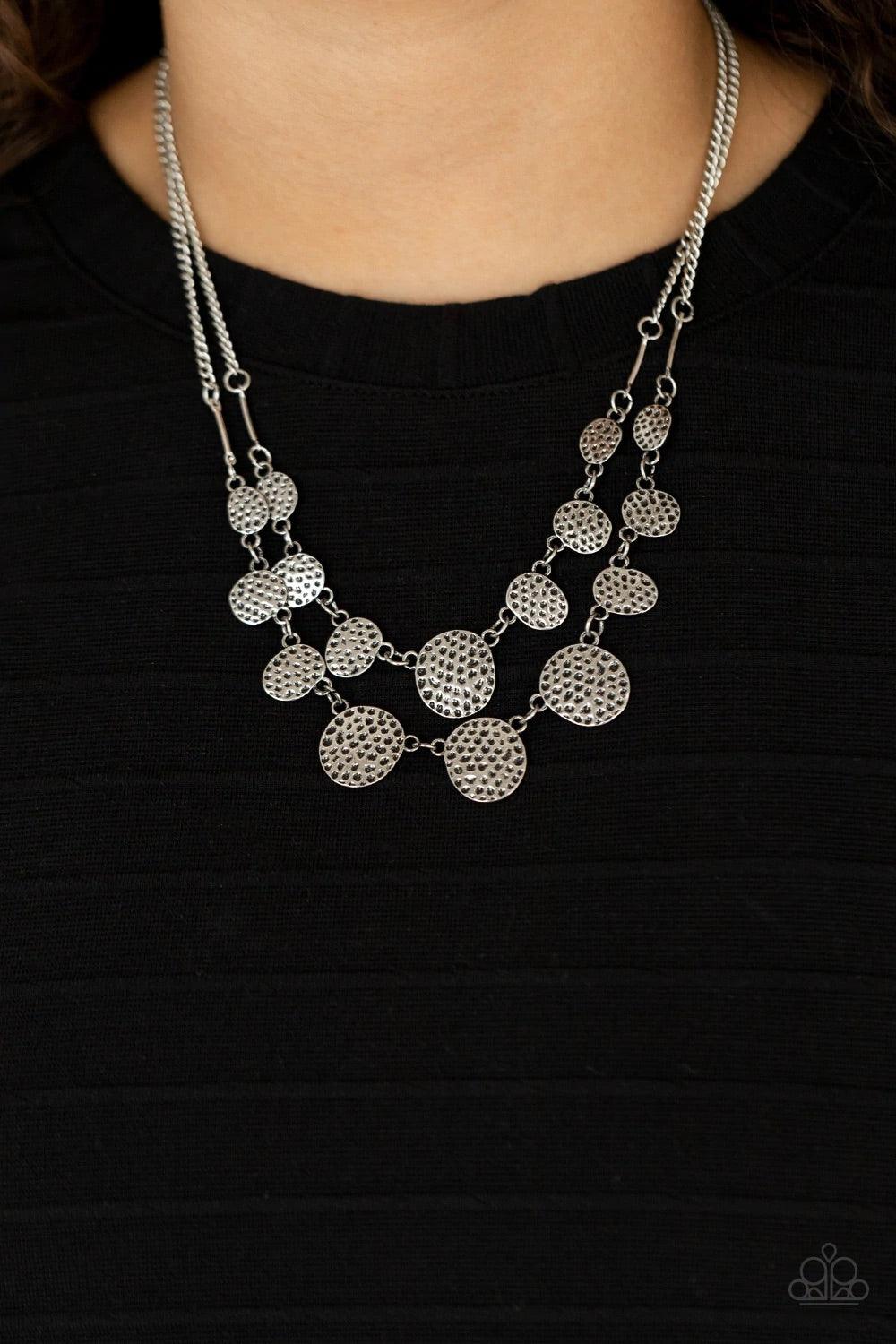 Paparazzi Accessories Pebble Me Pretty - Silver A double row of delicately hammered and dotted silver discs gently lay across the collar. Gradually increasing in size, they connect to silver chains for a simple statement. Features an adjustable clasp clos