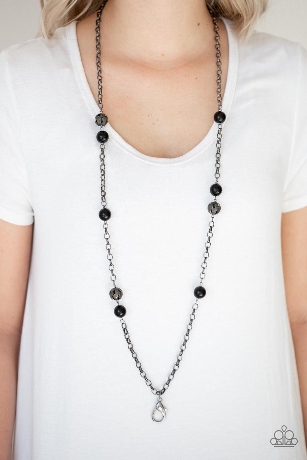 Paparazzi Accessories Fashion Fad - Black *Lanyard Shiny black beads and ornate gunmetal beads trickle along a bold gunmetal chain, creating a colorfully industrial look across the chest. A lobster clasp hangs from the bottom of the design to allow a name