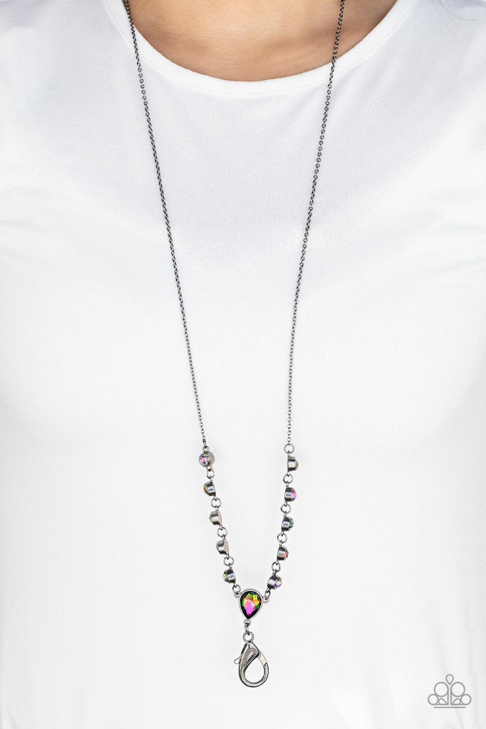 Paparazzi Accessories Unfathomable Fierceness - Multi A sparkly series of glassy oil spill rhinestones gives way to an oversized oil spill rhinestone teardrop pendant at the bottom of a dainty gunmetal chain. A lobster clasp hangs from the bottom of the d