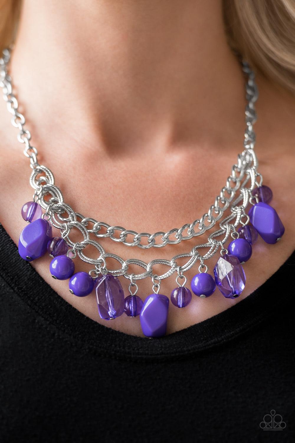 Paparazzi Accessories Brazilian Bay - Purple Featuring glassy and polished finishes, round and asymmetrical purple beads trickle from the bottom of a double-linked silver chain. An additional silver chain is layered above the summery beading for a seasona