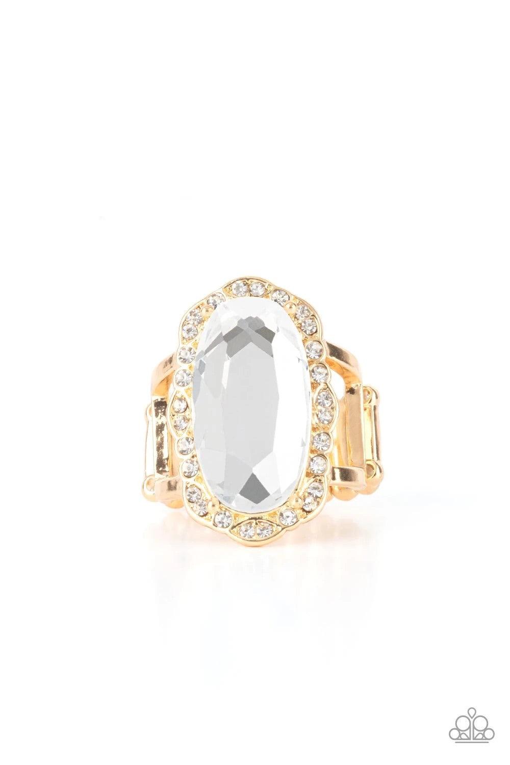 Paparazzi Accessories BLING to Heel! - Gold A dramatically oversized oval white gem adorns the center of a scalloped gold frame dusted in dainty white rhinestones, creating a commanding centerpiece atop the finger. Features a stretchy band for a flexible