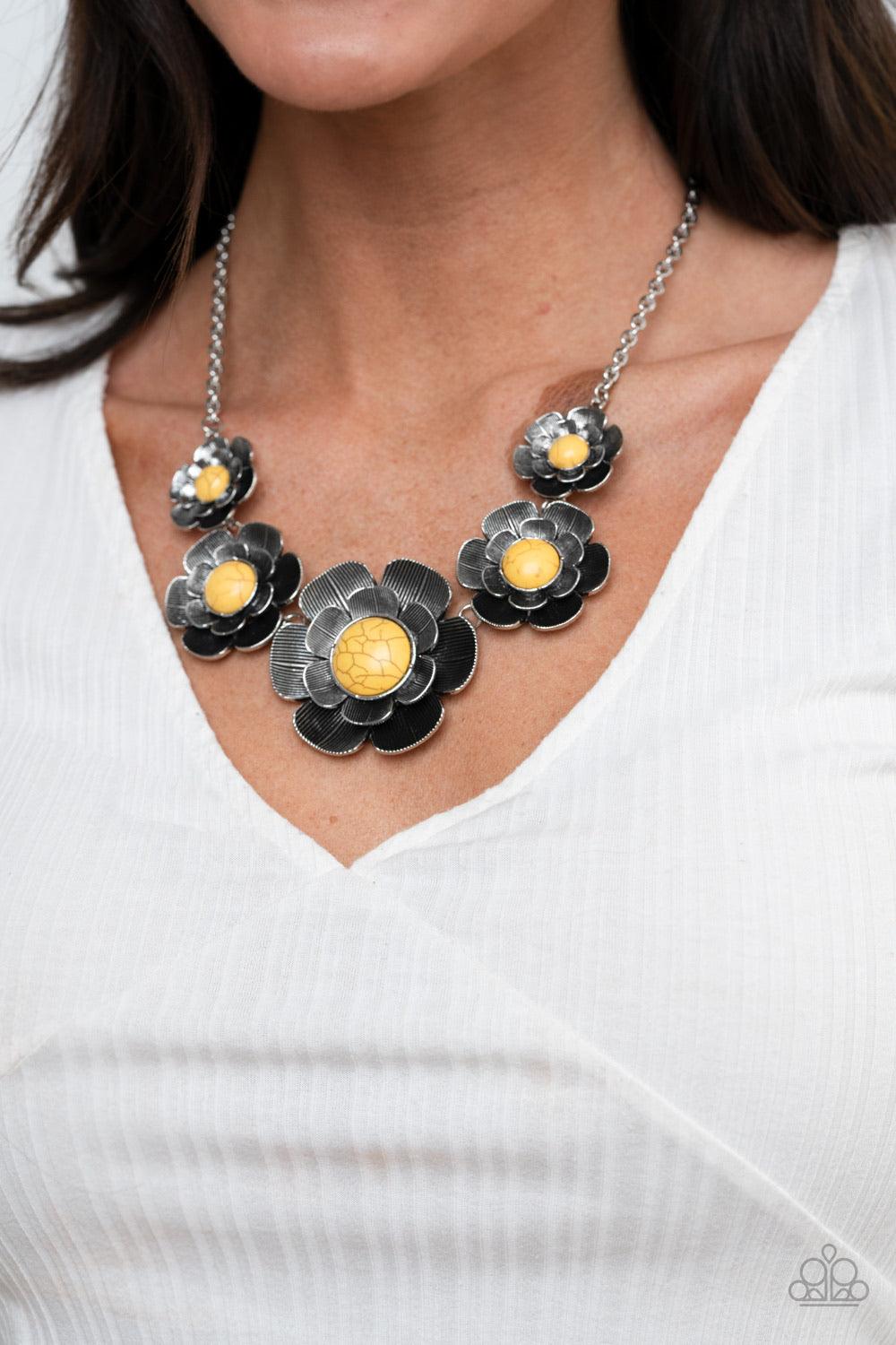 Paparazzi Accessories Bountiful Badlands - Yellow Layers of lifelike silver petals bloom from sunny yellow centers as they link below the collar for a seasonal statement-making look. The floral frames gradually increase in size as they inch towards the ce