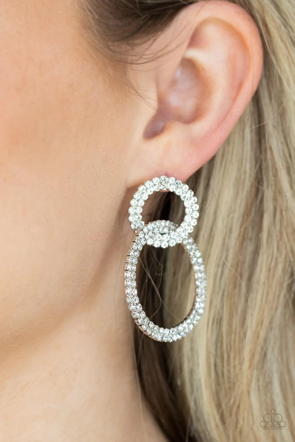 Paparazzi Accessories Intensely Icy - White Rows of sparkly white rhinestones encircle into two interconnected hoops, creating a jaw-dropping lure. Earring attaches to a standard post fitting. Sold as one pair of post earrings.