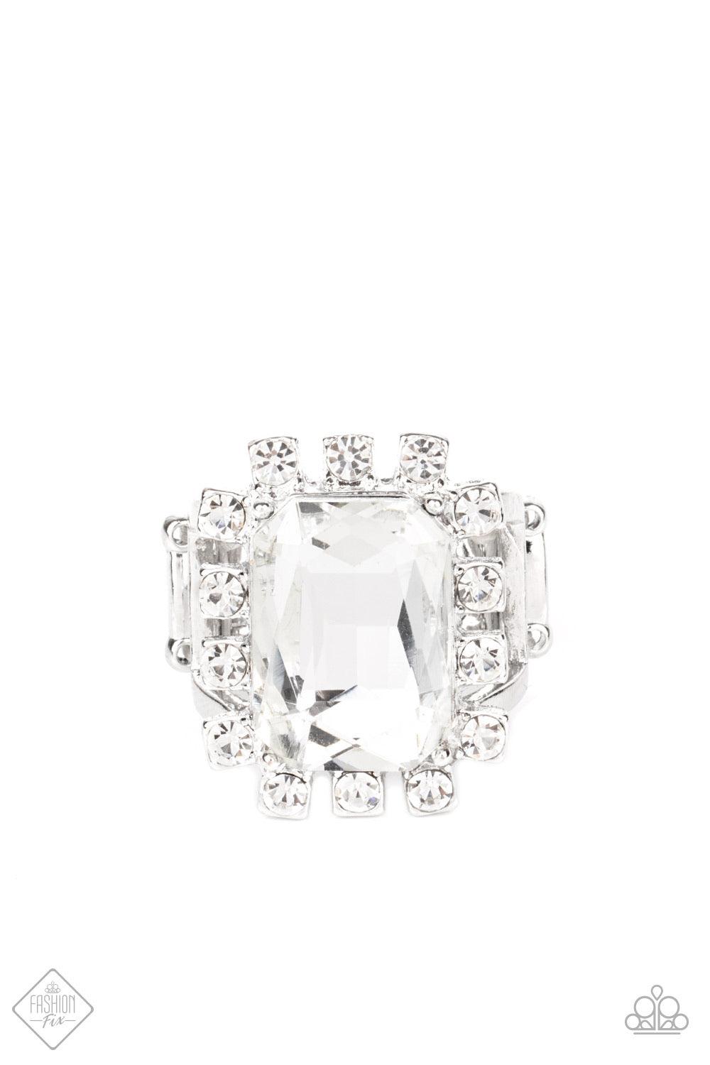 Paparazzi Accessories Galactic Glamour - White Featuring dainty silver square fittings, an explosion of glassy white rhinestones fans out from a dramatically oversized emerald cut rhinestone center, creating a stellar centerpiece atop the finger. Features