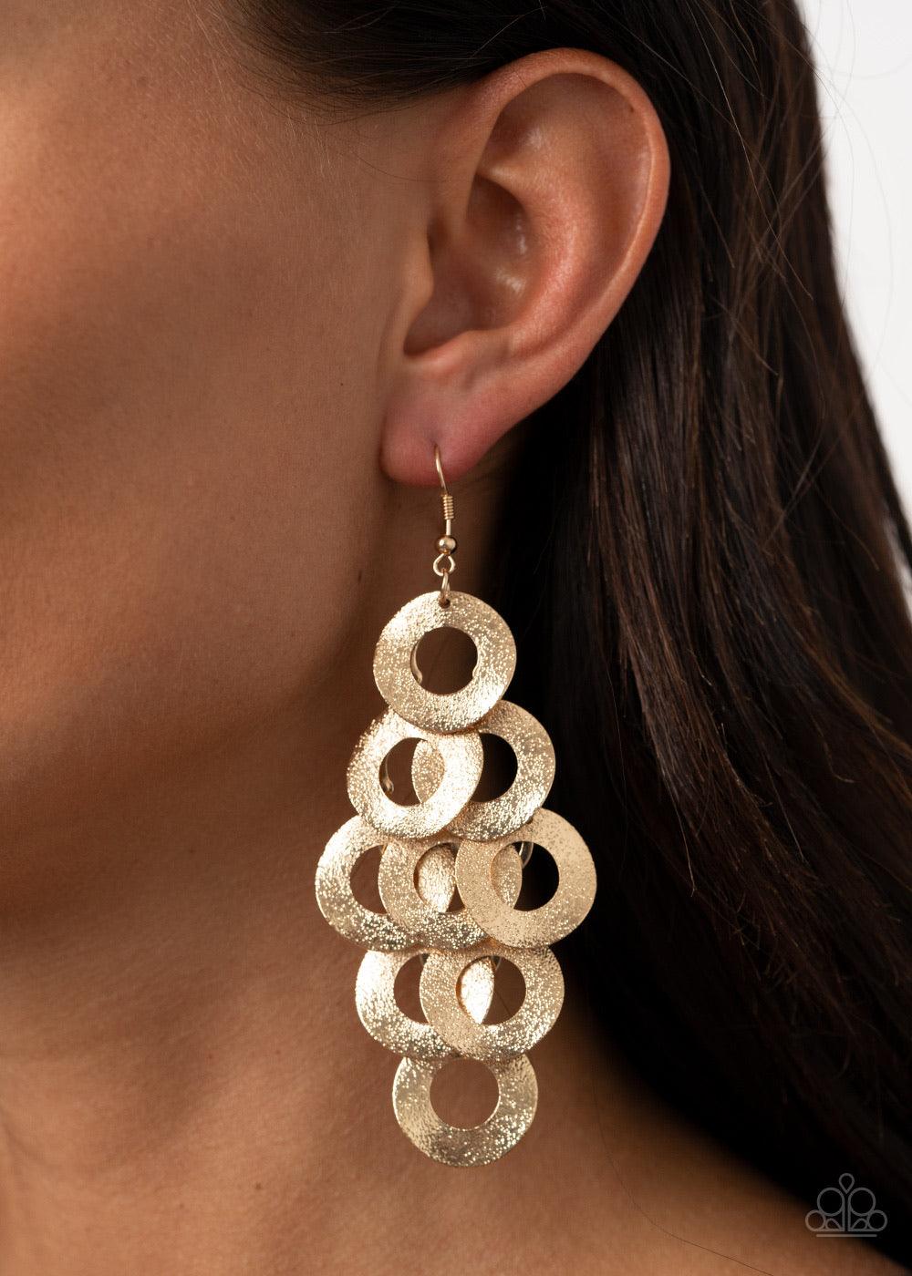 Paparazzi Accessories Scattered Shimmer - Gold Delicately hammered in light-catching shimmer, rows of curved gold hoops delicately overlap into a noise-making lure. Earring attaches to a standard fishhook fitting. Sold as one pair of earrings. Jewelry