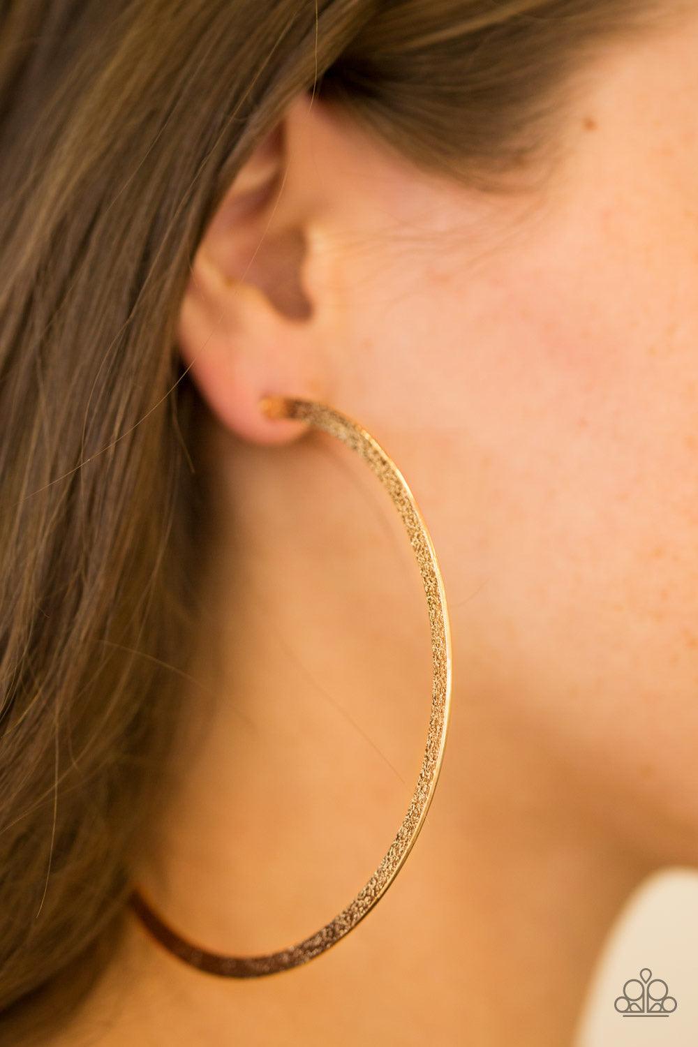 Paparazzi Accessories Size Them Up - Gold One side of a gold hoop is delicately hammered, adding blinding shimmer to the dramatic palette. Hoop measures 3 1/2” in diameter. Earring attaches to a standard post fitting. Jewelry