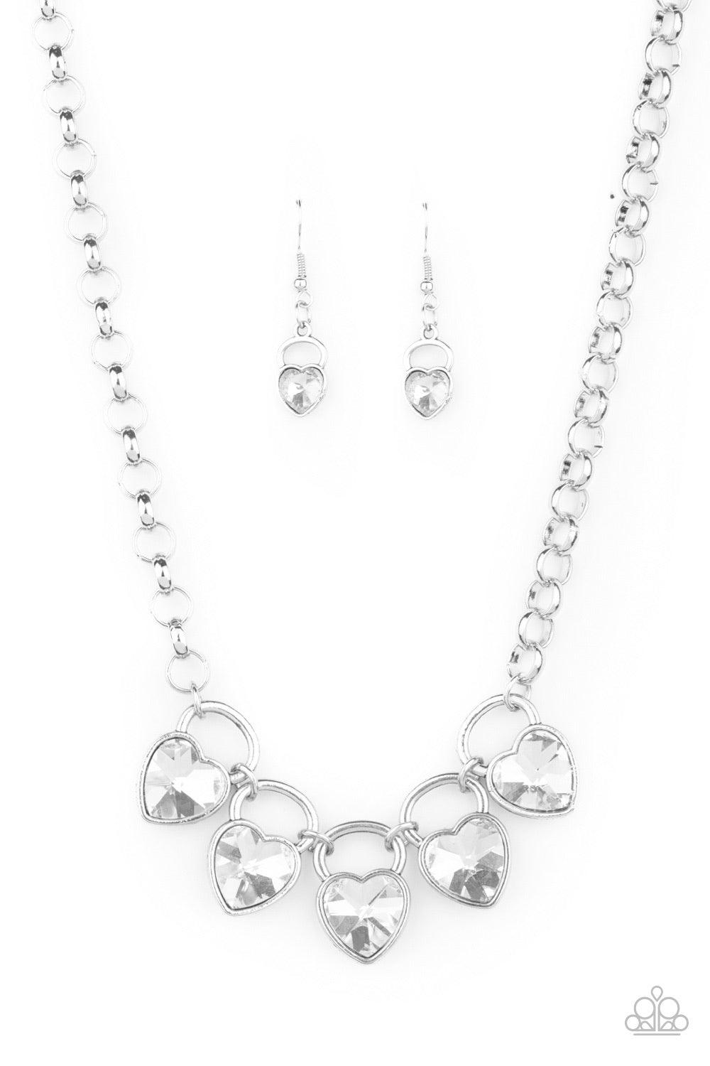 Paparazzi Accessories HEART on Your Heels - White Dotted with glittery white heart-shape gems, shimmery silver locket-like frames link together at the bottom of an exaggerated silver chain, creating a sparkling statement piece below the collar. Features a
