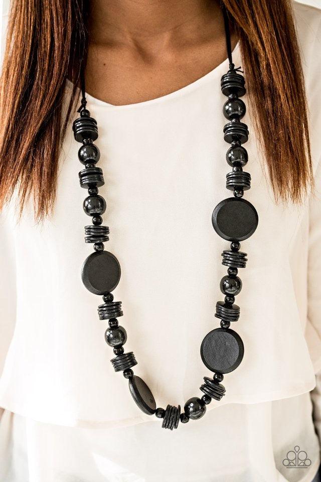 Paparazzi Accessories Tiki Tonga - Black Brushed in a shiny black finish, round wooden beads and discs are threaded along strands of black thread. Dramatic wooden accents are sprinkled between the stacked beading, adding bold earthy accents to the summery