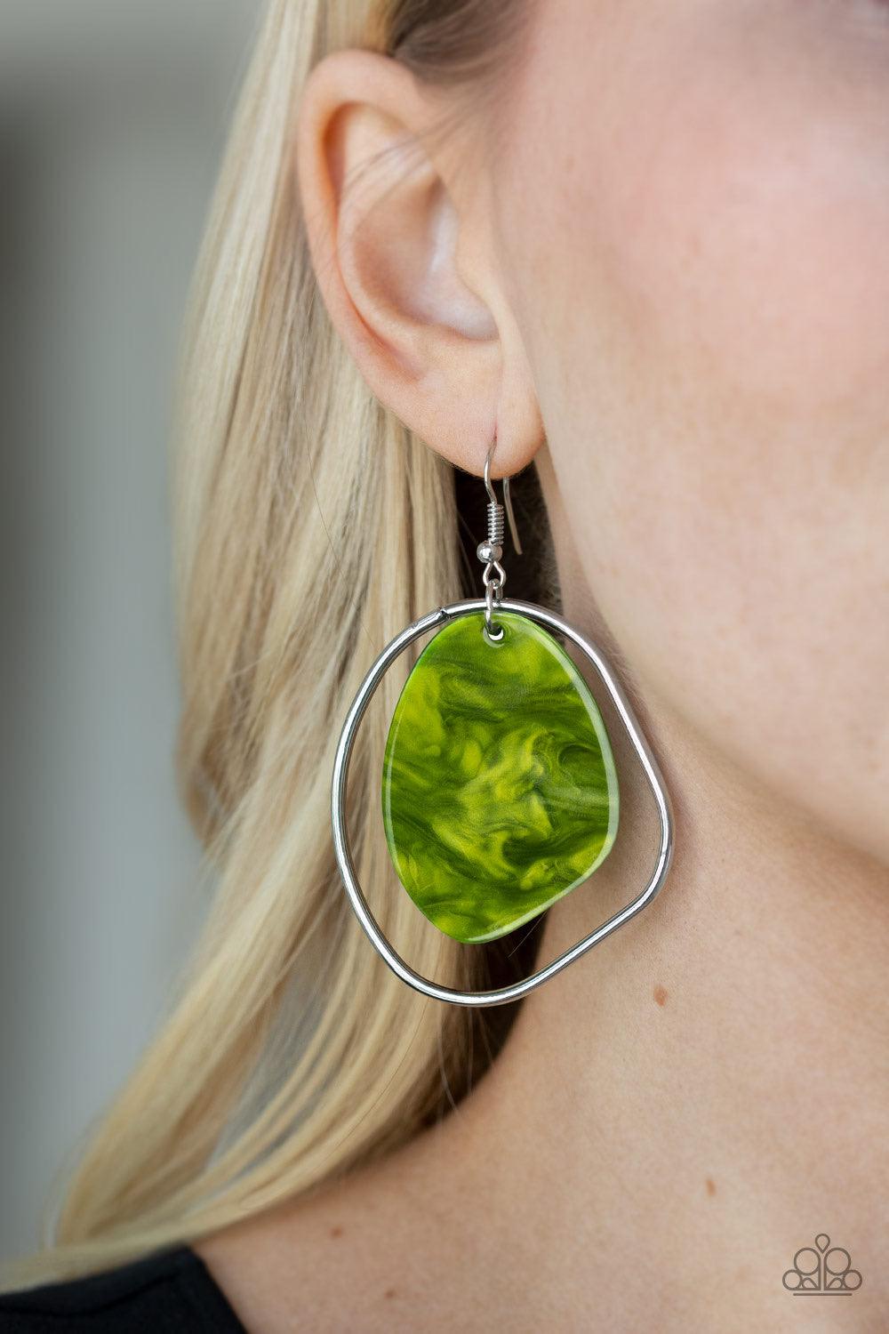 Paparazzi Accessories HAUTE Toddy - Green Brushed in a green shell-like iridescence, an abstract acrylic frame swings from the top of an asymmetrical silver hoop for a seasonal flair. Earring attaches to a standard fishhook fitting. Jewelry