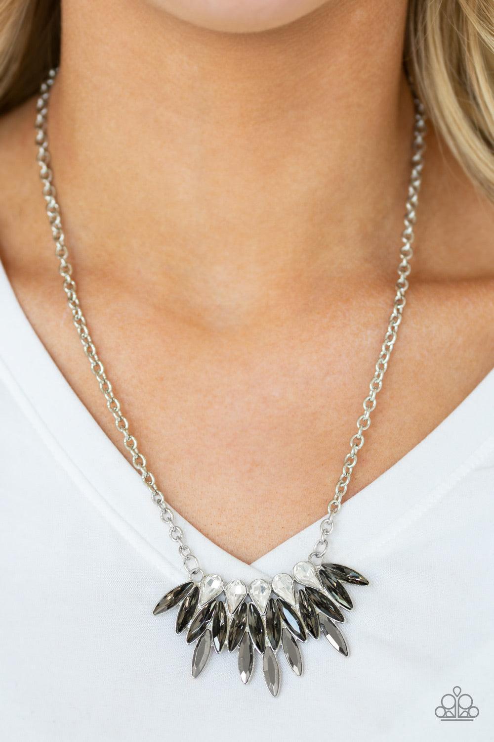 Paparazzi Accessories Crown Couture - Silver Featuring regal teardrop and marquise style cuts, glittery white, smoky gray, and glassy hematite rhinestones fan below the collar for a dramatic look. Features an adjustable clasp closure. Sold as one individu