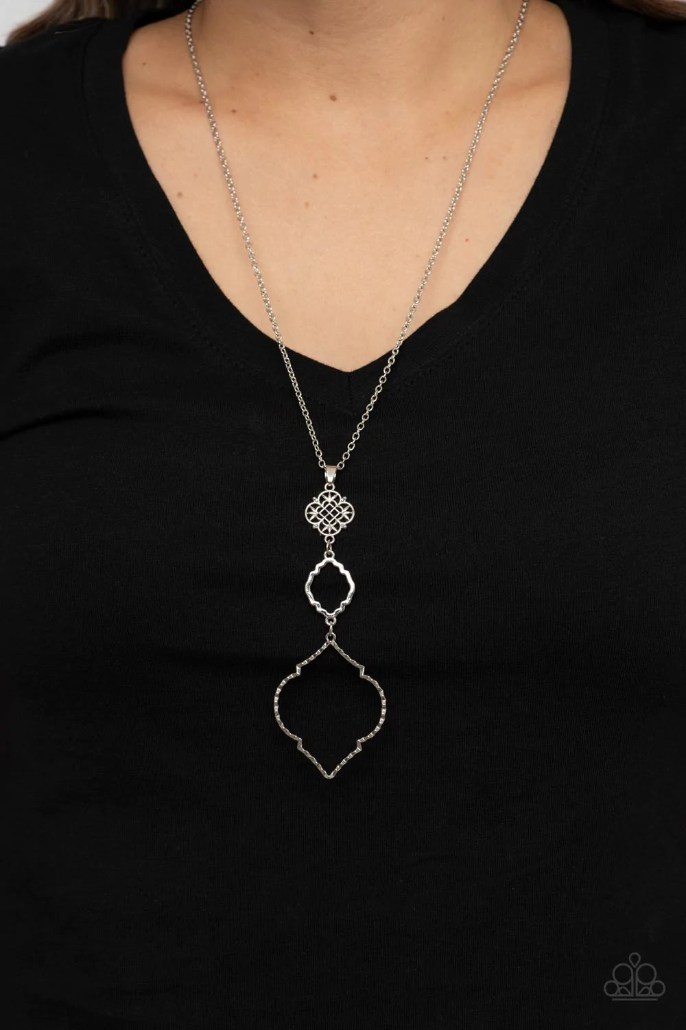 Paparazzi Accessories Marrakesh Mystery - Silver Featuring mandala-like patterns, a floral lattice frame gives way to mismatched scalloped silver frames, creating a magnificently stacked pendant at the bottom of an extended silver chain. Features an adjus