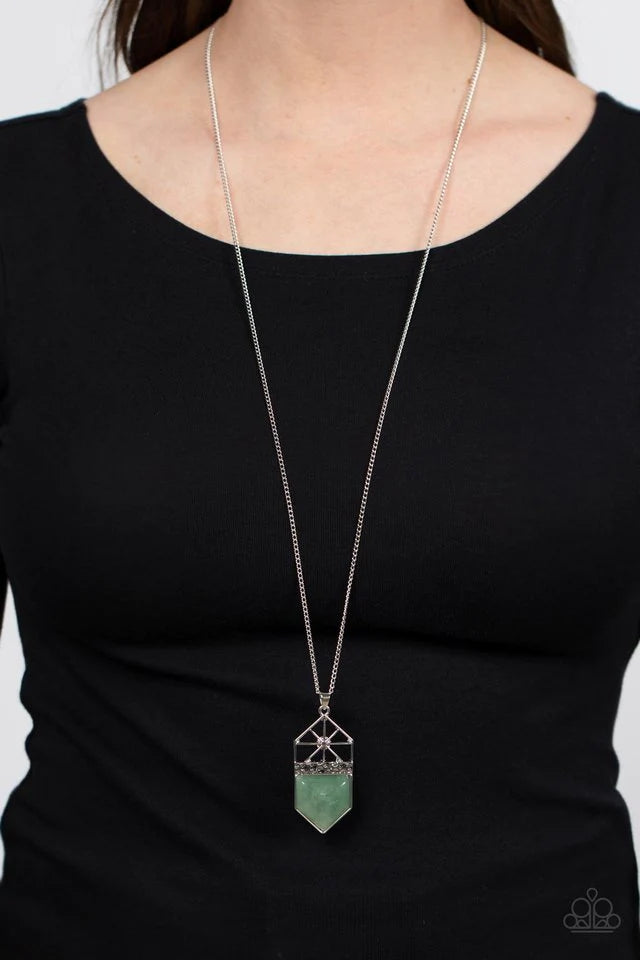 Paparazzi Accessories Trailblazing Talisman - Green This lucky charm features a polished jade stone that lies below a hammered silver metal bar and a shiny silver starburst top. The earthy pendant swings from the bottom of a lengthened silver chain, resul