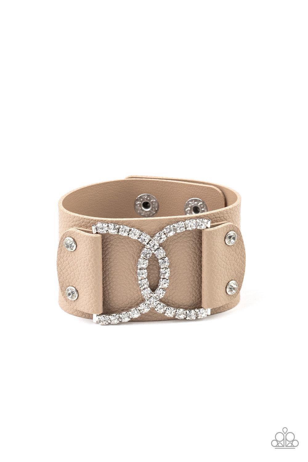 Paparazzi Accessories Couture Culture - Brown Encrusted in glassy white rhinestones, two interlocking half moon silver frames are studded in place across the front of a brown leather band for a statement-making finish. Features an adjustable snap closure.