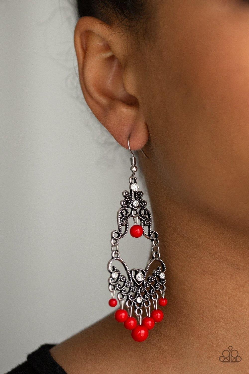 Paparazzi Accessories Colorfully Cabaret - Red Infused with hints of glittery white rhinestones, dotted silver filigree swirls into a decorative frame. Polished red beads swing from the bottom and top of the ornate frame, adding colorful movement to the w