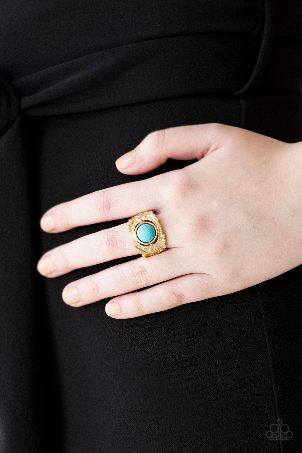 Paparazzi Accessories Stand Your Ground - Gold A refreshing turquoise stone is pressed into an ornate gold band radiating with rope-like and studded textures for a seasonal look. Features a stretchy band for a flexible fit. Jewelry