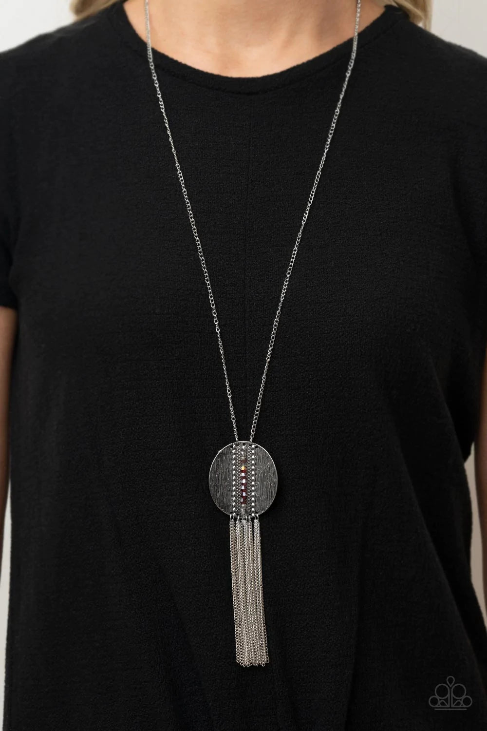 Paparazzi Accessories Radical Refinery - Red An oversized concave silver disc, ribbed with linear texture, creates a dramatic backdrop for a vertical row of faceted red beads. A flirty tassel of delicate silver chains sways from the bottom of the pendant