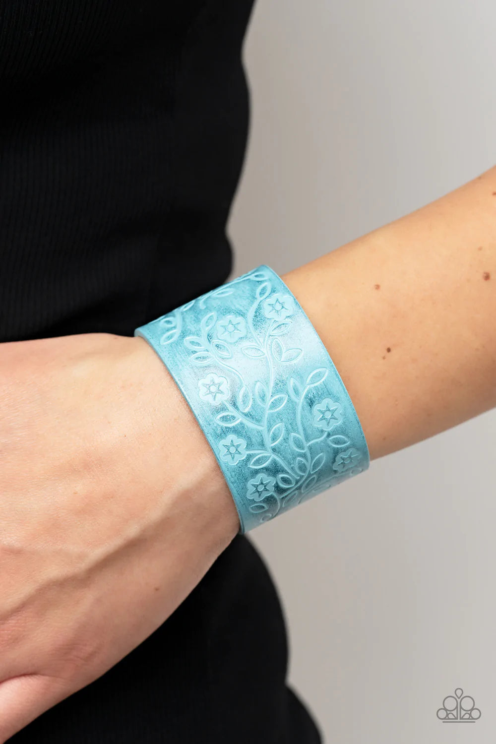 Paparazzi Accessories Rosy Wrap Up - Blue A flowery and leafy motif blooms across the front of a distressed blue leather band, resulting in a rustic floral centerpiece around the wrist. Features an adjustable snap closure. Sold as one individual bracelet.
