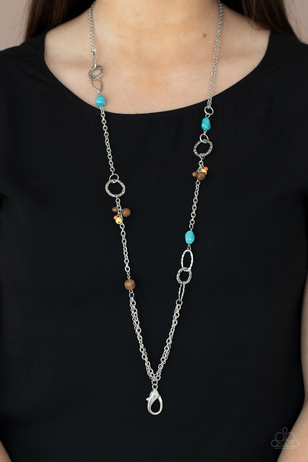 Paparazzi Accessories Sandstone Safari - Multi *Lanyard A mismatched collection of brown wooden beads, turquoise pebbles, hammered silver ovals, and dainty multicolored stone beads haphazardly adorned sections of silver chain across the chest, creating an