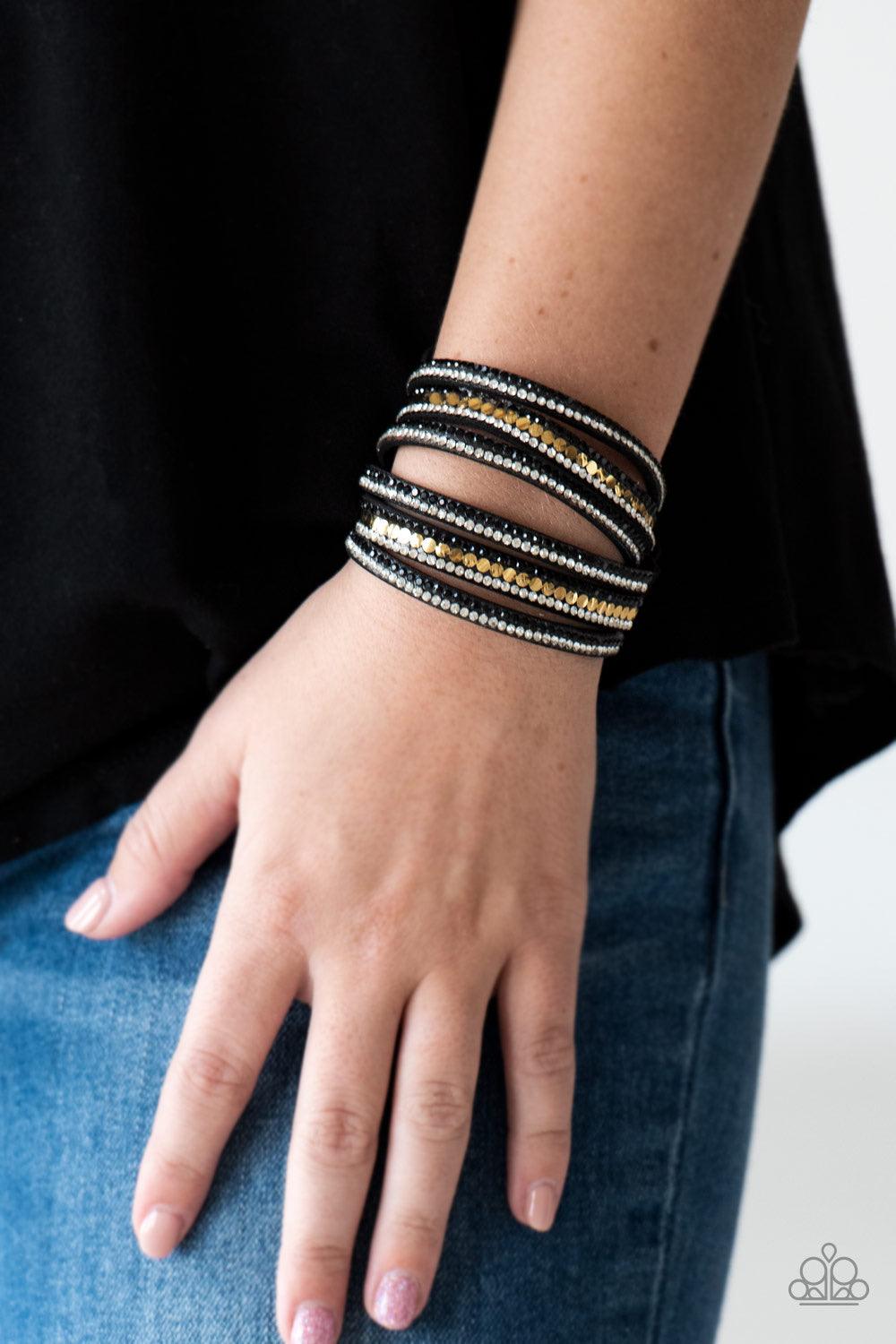 Paparazzi Accessories Rock Star Attitude - Gold Encrusted in rows of glittery black and white rhinestones and flat gold studs, three strands of black suede wrap around the wrist for a sassy look. The elongated band allows for a trendy double wrap around t