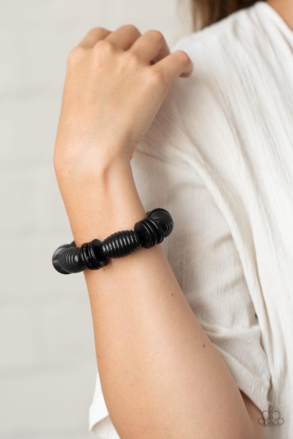 Paparazzi Accessories Caribbean Castaway - Black A summery collection of oversized black wooden beads and distressed black wooden discs are delicately threaded along stretchy bands around the wrist for a beach inspired fashion. Sold as one individual brac