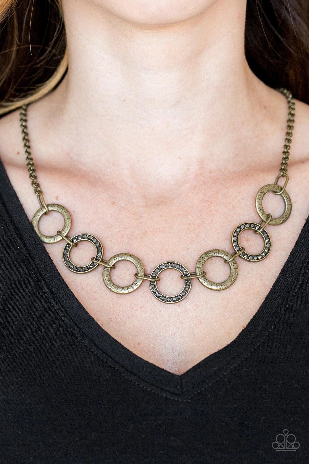 Paparazzi Accessories Modern Day Madonna - Brass Textured brass hoops and glittery hematite rhinestone encrusted hoops link below the collar for a sassy industrial look. Features an adjustable clasp closure. Sold as one individual necklace. Includes one p