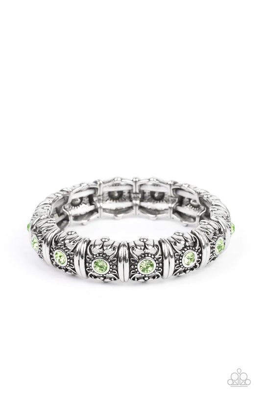 Paparazzi Accessories Angeless Glow - Green Centered around silver intricate, floral casings, green rhinestones glimmer on threaded stretchy bands around the wrist for an ageless look. Sold as one individual bracelet. Jewelry