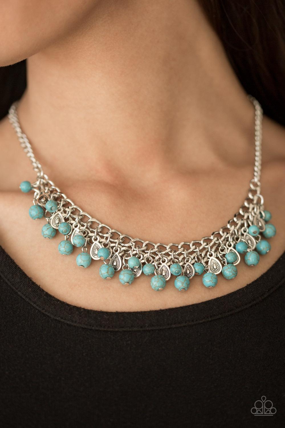 Paparazzi Accessories Poshly Paleo - Blue Earthy turquoise stone beading cascades from the bottom of interlocking silver chains, creating an earthy fringe below the collar. Brushed in an antiqued shimmer, textured silver teardrops drip between the colorfu