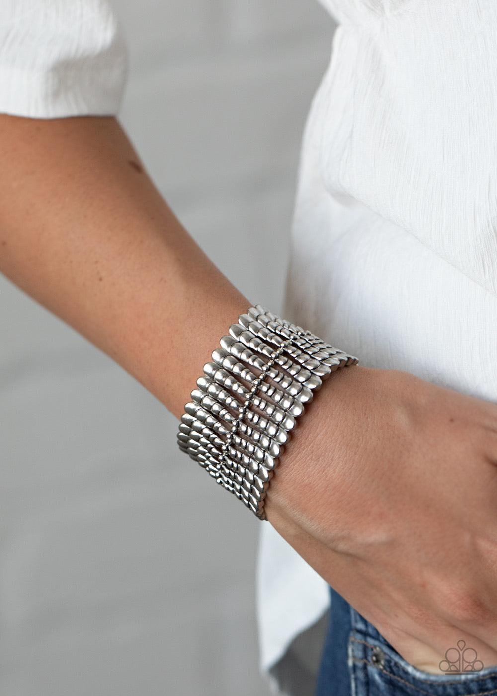 Paparazzi Accessories Level Field - Silver Infused with dainty silver beads, rippling silver bars are threaded along stretchy bands around the wrist, creating a rustic centerpiece. Sold as one individual bracelet. Jewelry