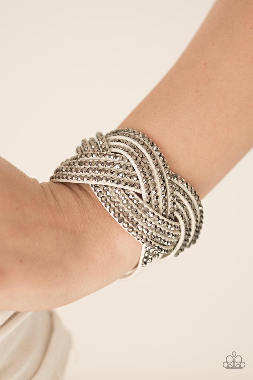 Paparazzi Accessories Top Class Chic - White Oversized hematite rhinestones are encrusted along strands of crisscrossing white suede, creating a fierce shimmer around the wrist. Features an adjustable snap closure. Jewelry