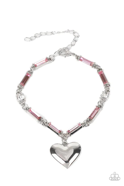 Paparazzi Accessories Sweetheart Secrets - Pink Encased in sleek silver fittings, classic white rhinestones and emerald cut pink rhinestones delicately link into a sparkly chain around the wrist. A shiny silver heart charm swings from the glittery compila