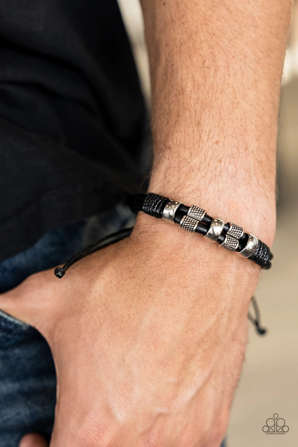 Paparazzi Accessories Urban Cattle Drive - Black Shiny and textured silver cylindrical accents slide along a double layer of thick black leather cording. Glossy thread wrangles the ends together creating a rustic finish as it wraps around the wrist. Featu