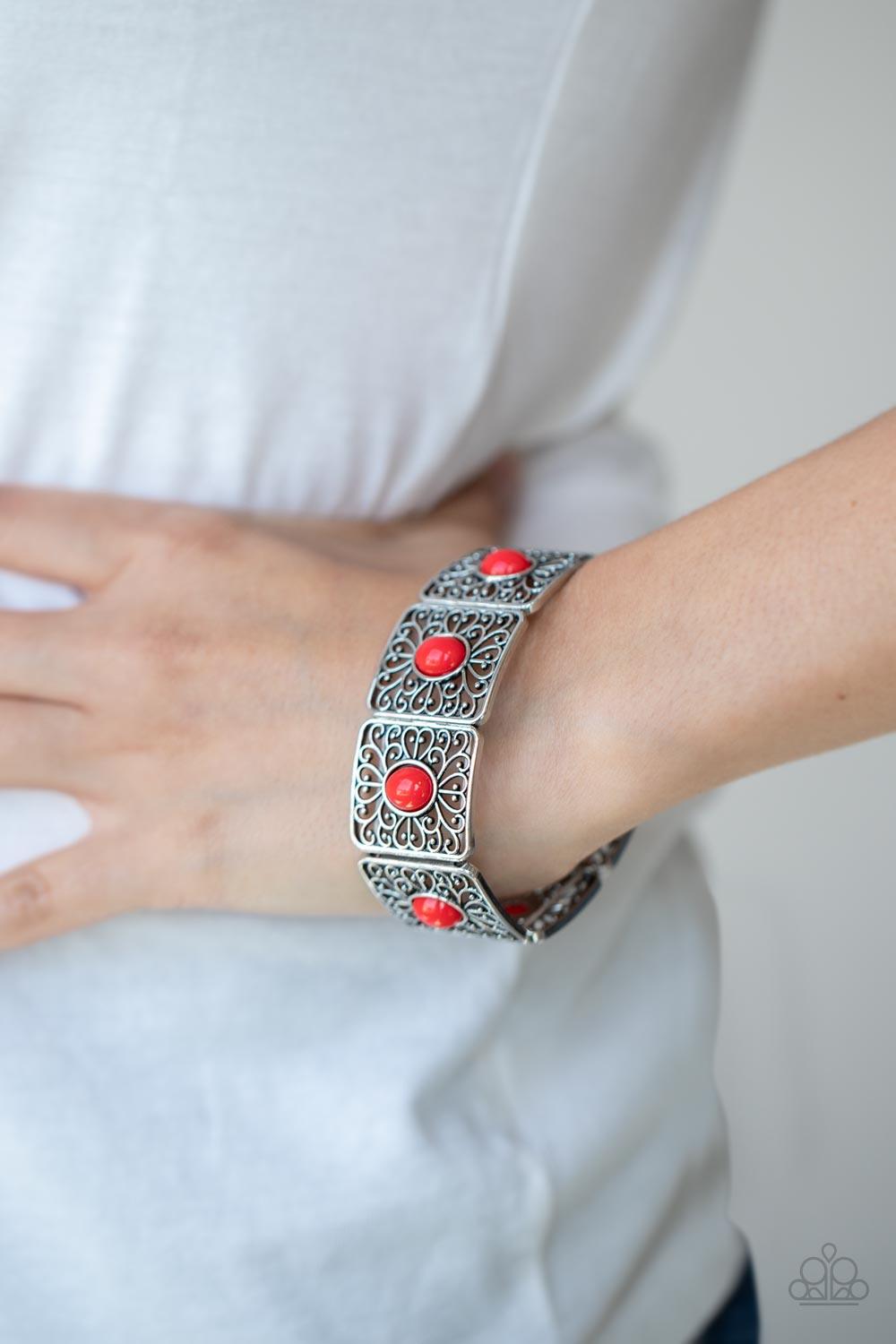 Paparazzi Accessories Cakewalk Dancing - Red A red oval bead is pressed into the center of an airy square frame featuring whimsical heart-shaped and vine-like filigree. The patterned frames are threaded along stretchy bands to repeat around the wrist crea