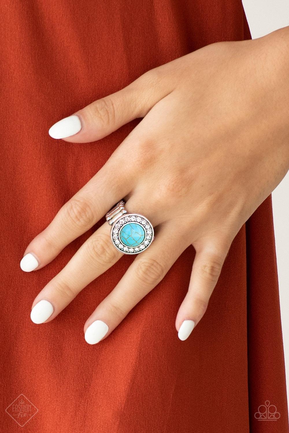 Paparazzi Accessories Rugged Radiance - Blue A refreshing turquoise stone is pressed into the center of a round silver frame radiating with glassy white rhinestones, creating an earthy, yet refined design. Features a stretchy band for a flexible fit. Jewe