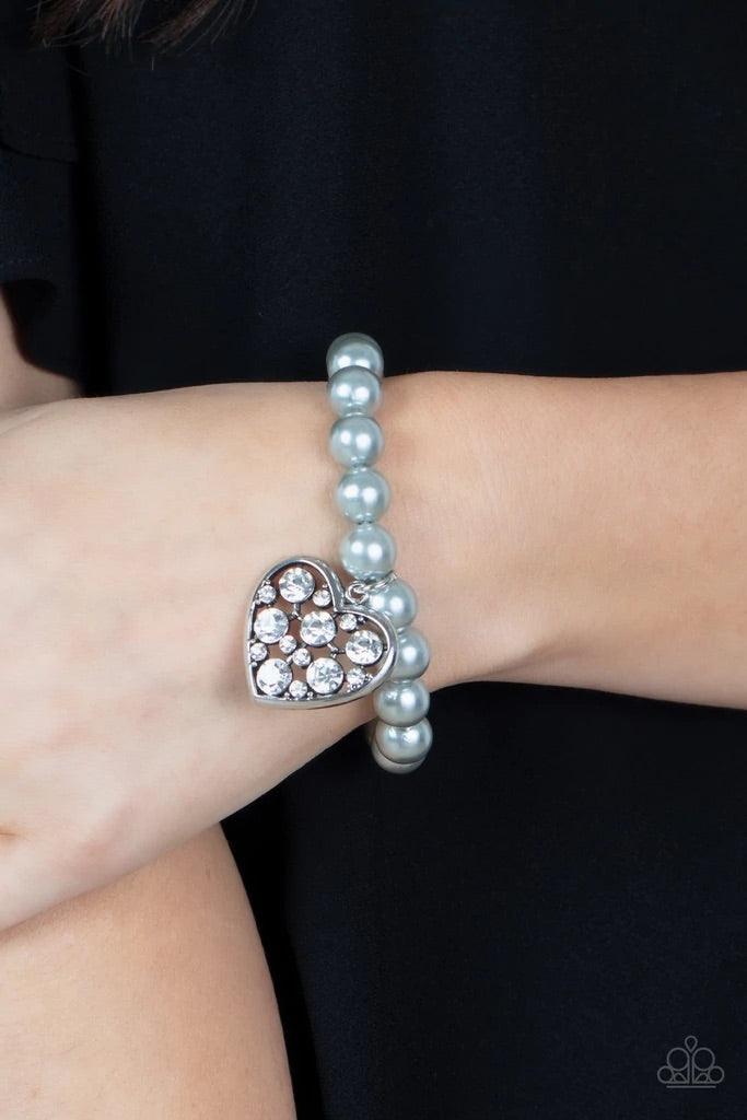 Paparazzi Accessories Cutely Crushing - Silver A dramatically oversized white rhinestone encrusted silver heart charm dangles from a stretchy strand of bubbly silver pearls, creating a flirtatious dazzle. Sold as one individual bracelet. Jewelry