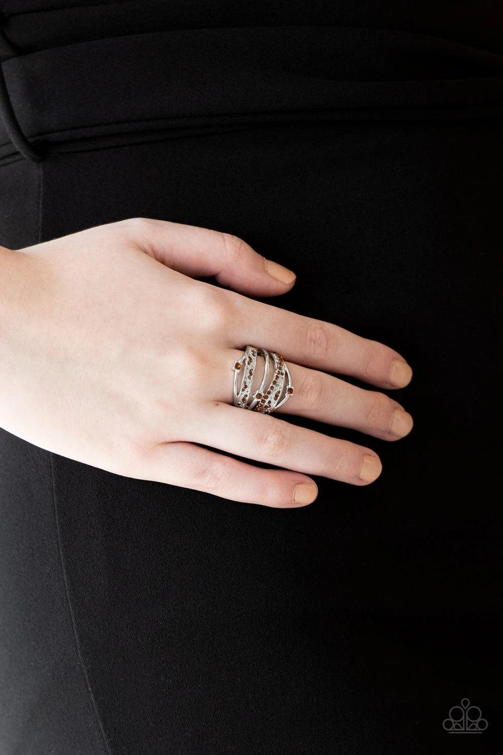 Paparazzi Accessories Making The World Sparkle - Brown Mismatched silver bands arc across the finger, coalescing into an airy frame. Dainty rhinestones are sporadically sprinkled across the shimmery layers for a refined finish. Features a stretchy band fo
