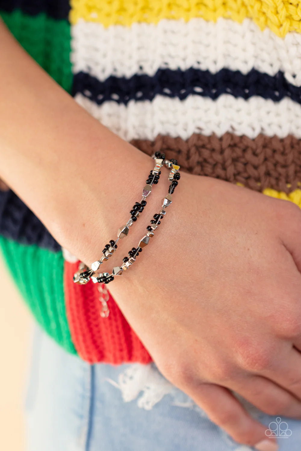 Paparazzi Accessories Elite Explorer - Black A dainty collection of faceted silver beads, black seed beads, and silver cubes are threaded along multiple strands of silver wire around the wrist, creating clustered layers. Features an adjustable clasp closu