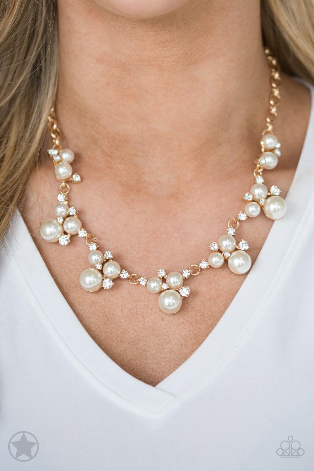 Paparazzi Accessories Toast To Perfection - Gold Clusters of pearls and dazzling white rhinestones join below the collar, creating refined frames. Infused with a glistening gold chain, the sections of luminescent frames trickle along the neck in a timeles