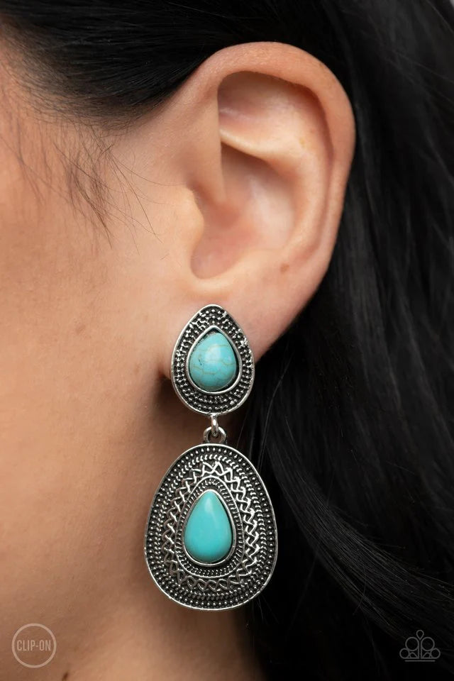 Paparazzi Accessories Country Soul - Blue *Clip-On Dotted with turquoise teardrop stones, rustic silver frames that are decoratively embossed and studded in patterns delicately link into an artisan inspired lure. Earring attaches to a standard clip-on fit
