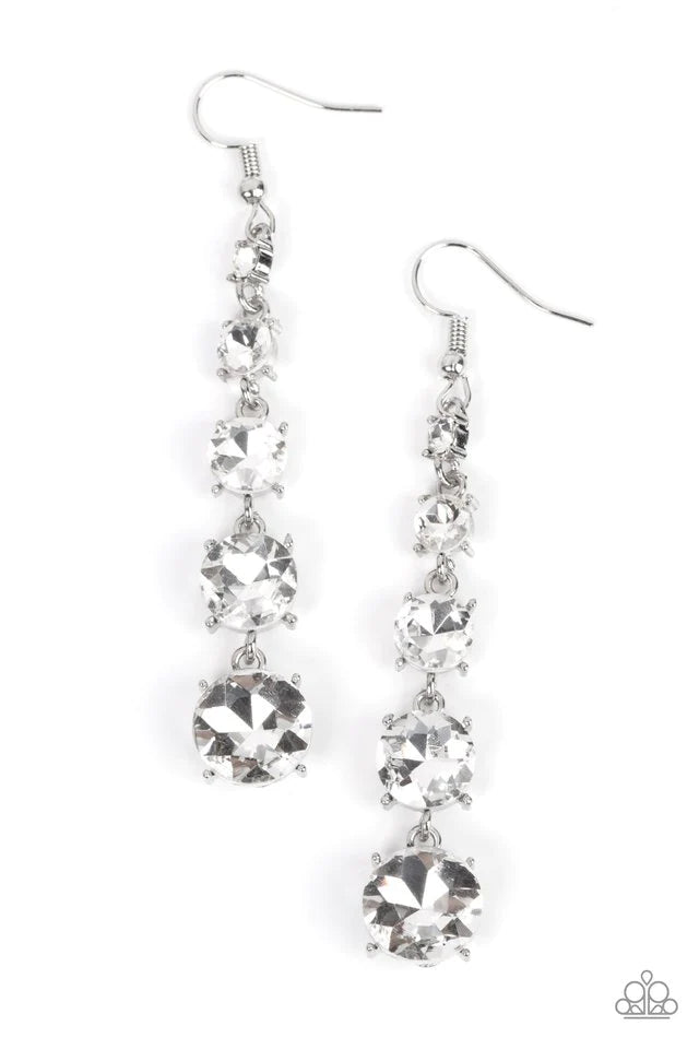 Paparazzi Accessories Red Carpet Charmer - White Encased in pronged silver fittings, a dramatic display of glittery white rhinestones gradually increase in size as they trickle from the ear for a timeless look. Earring attaches to a standard fishhook fitt