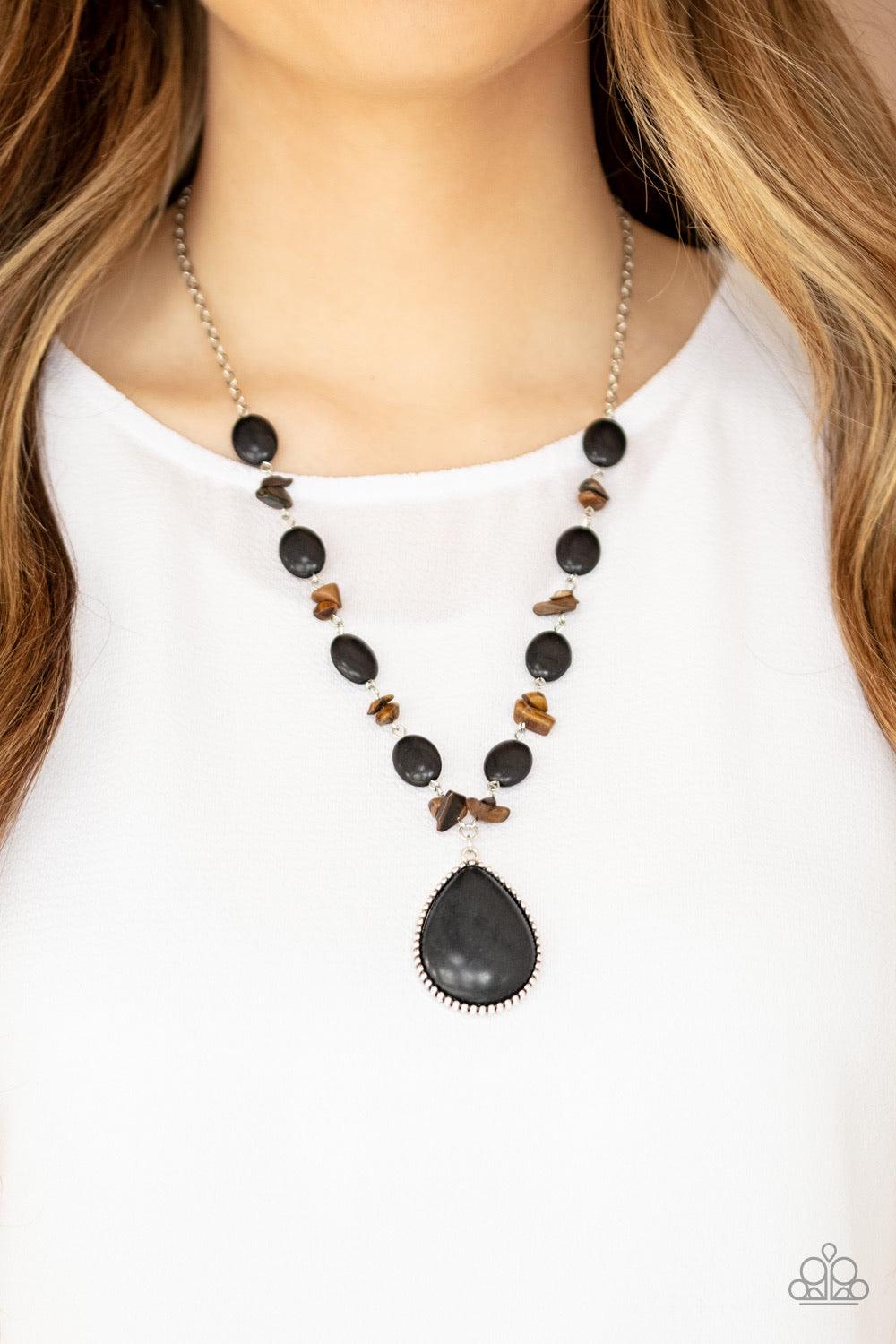 Paparazzi Accessories Desert Diva - Black Earthy black stones join bits of tiger's eye rock along a silver chain below the collar. Featuring a studded silver frame, an oversized black teardrop stone pendant swings from the center for a statement-making fi